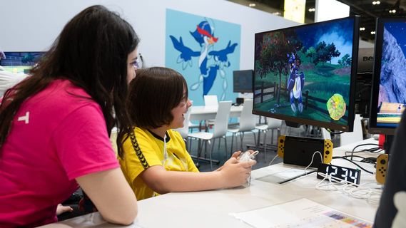 A child being taught how to play a Pokémon video game