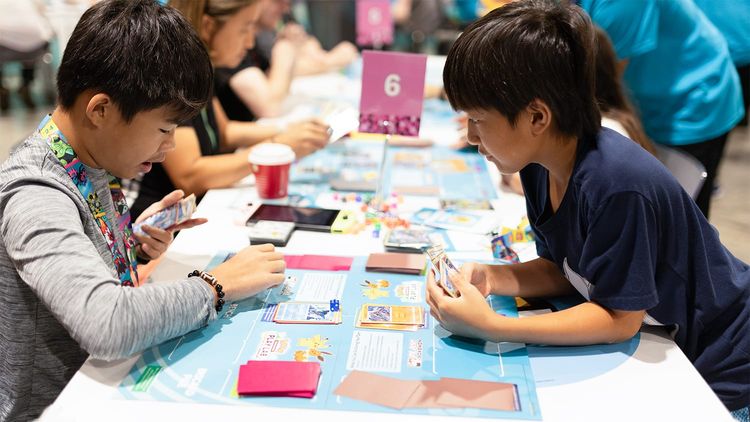 Two kids playing the demo deck battle format